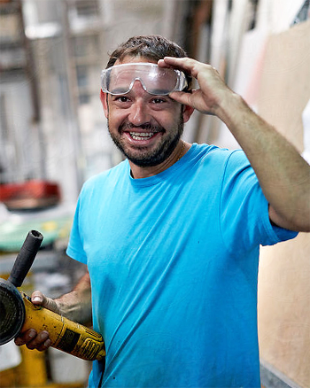 A Central Piedmont student wearing goggles and holding a sander