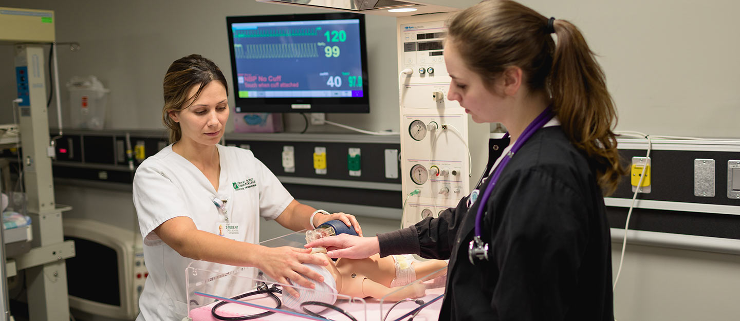 nurse aide simulating cpr on infant