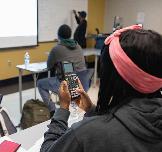 Student working with a calculator