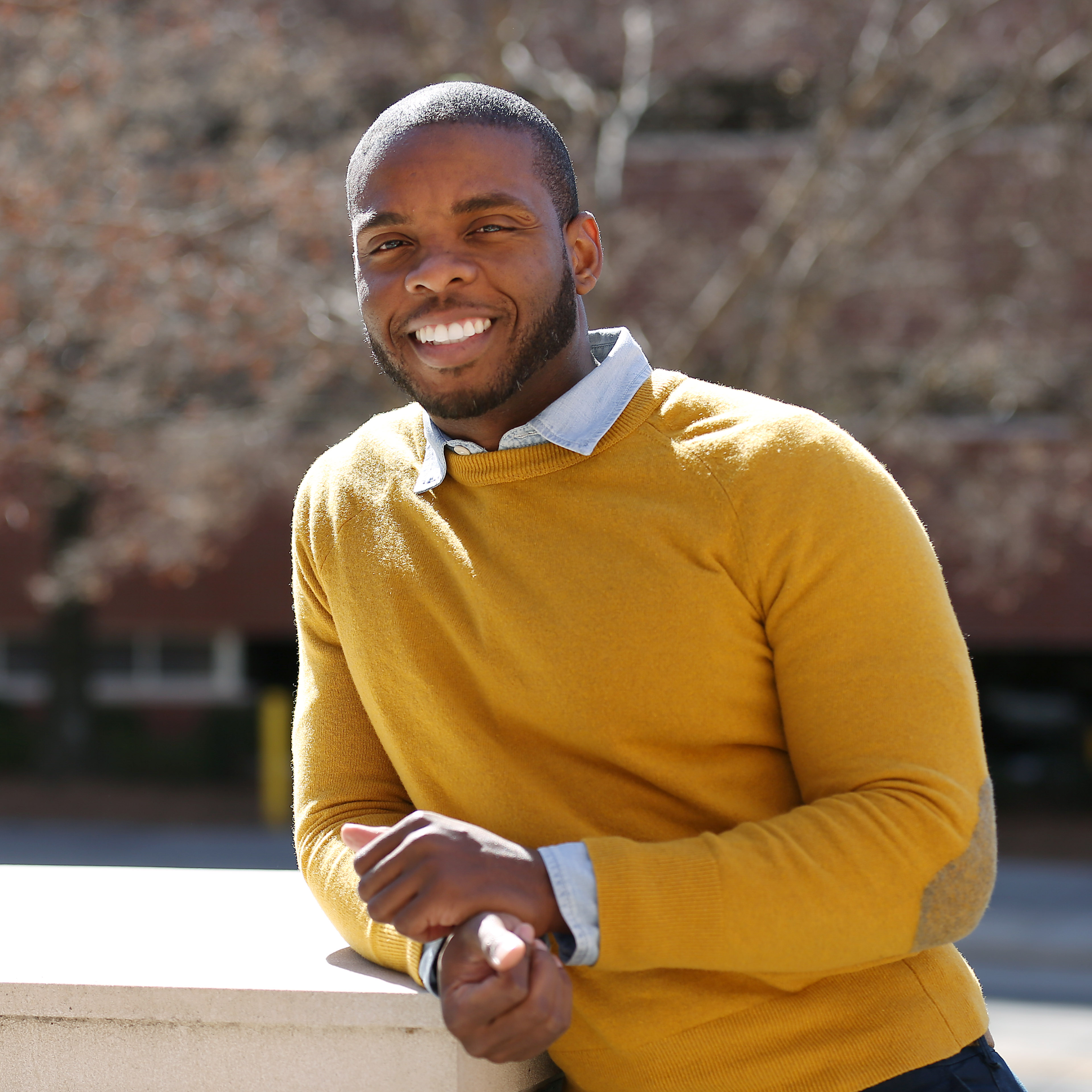 Continuing Education student Aaron Rogers smiling and leaning against wall outside