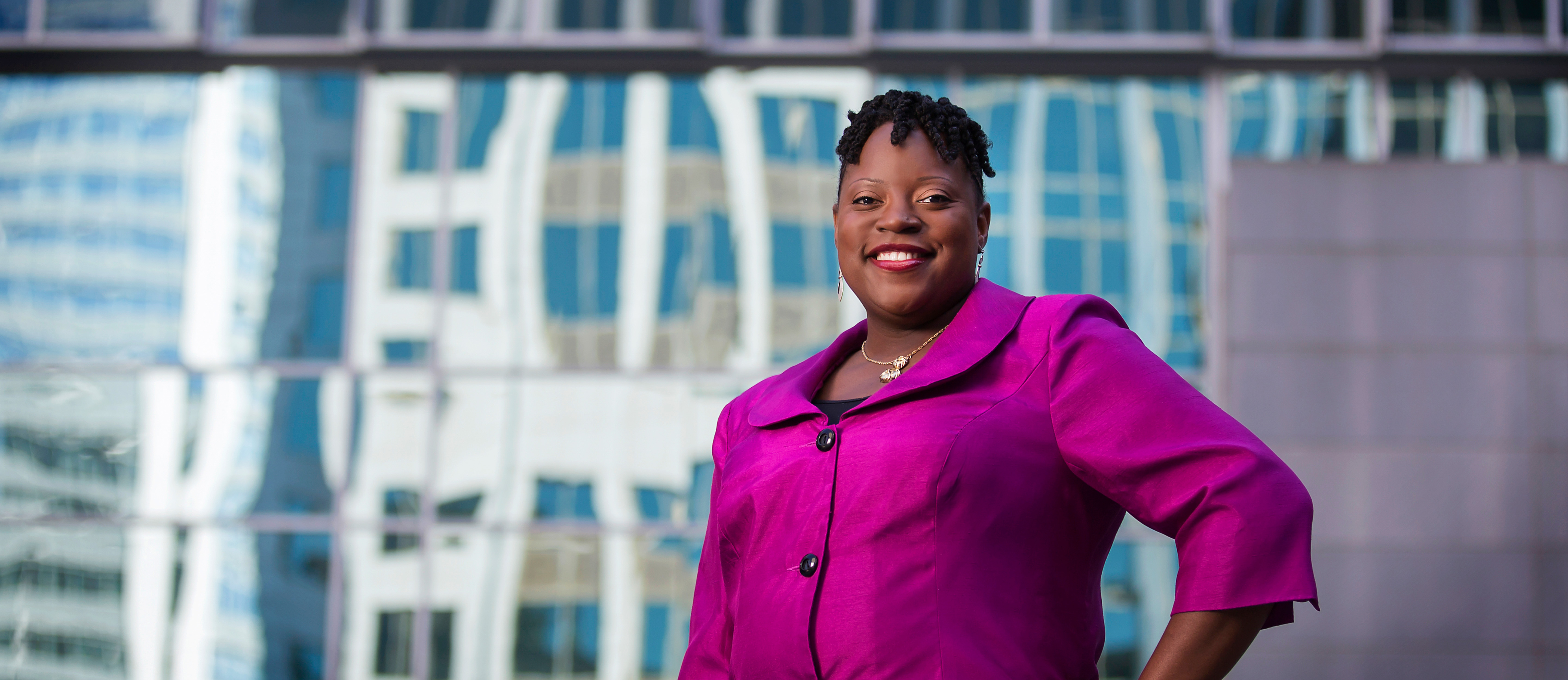 corporate and continuing education professional smiling in front of skyscraper