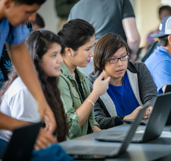 students working on laptops in classroom