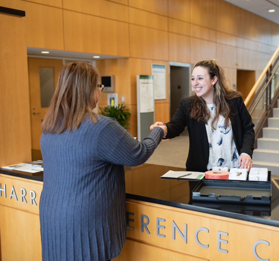 hospitality student greeting guest at conference center