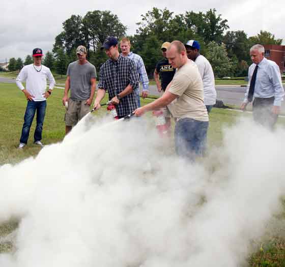 Fire protection students practicing with fire extinguishers