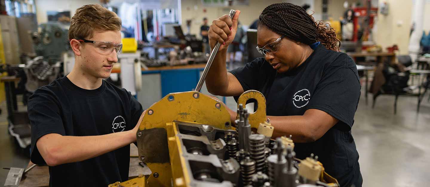 Two students repairing a disel engine