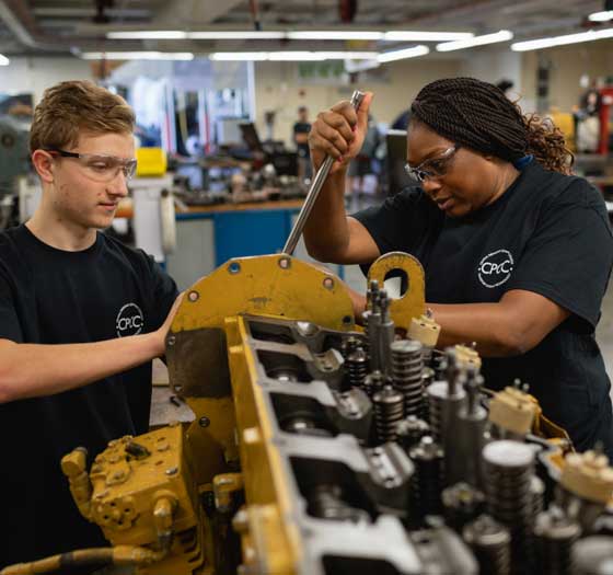 Two students working on a diesel engine