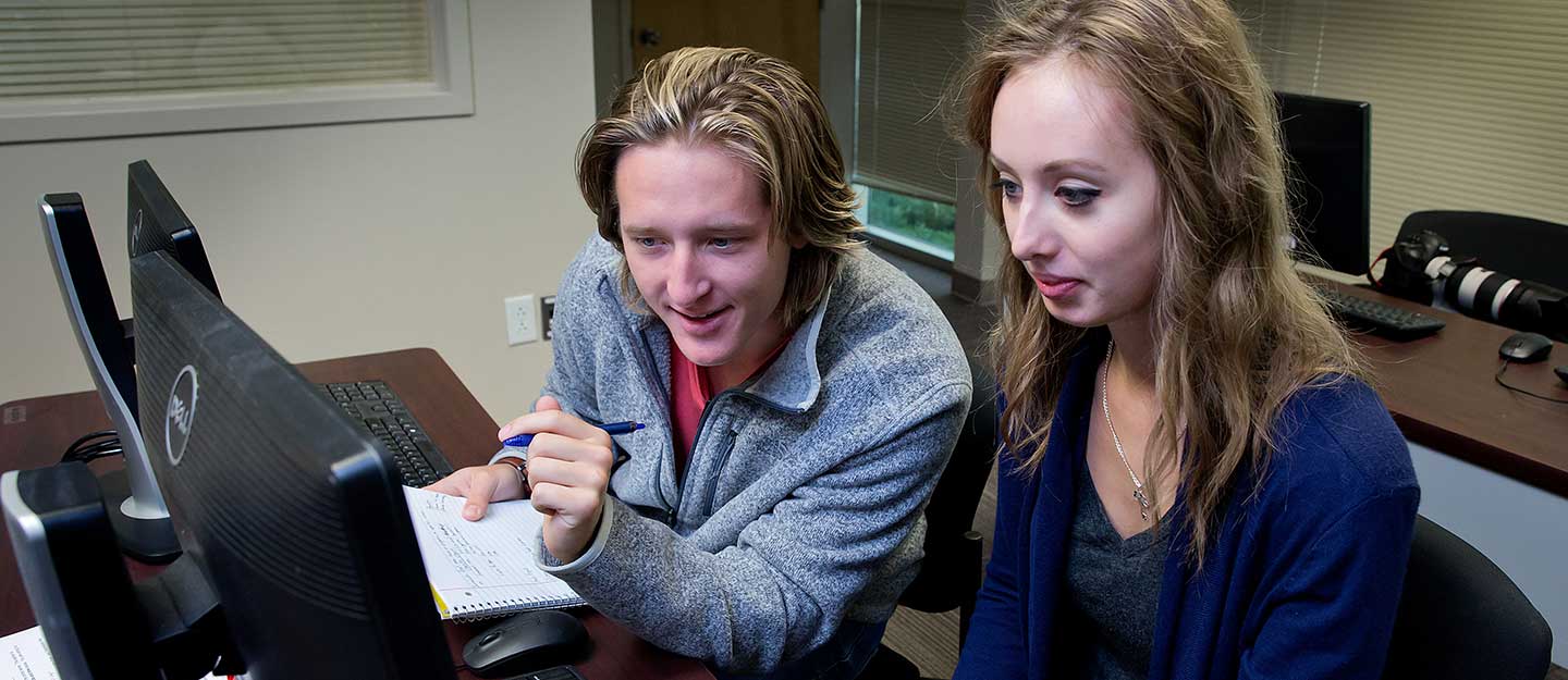 Students using a computer to write a paper