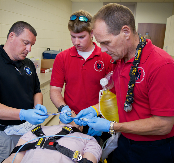 paramedic students administering aid to dummy