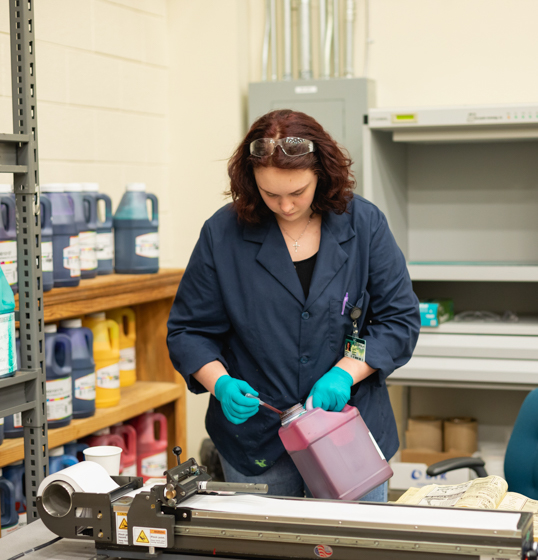 woman working in graphic arts facility with paint