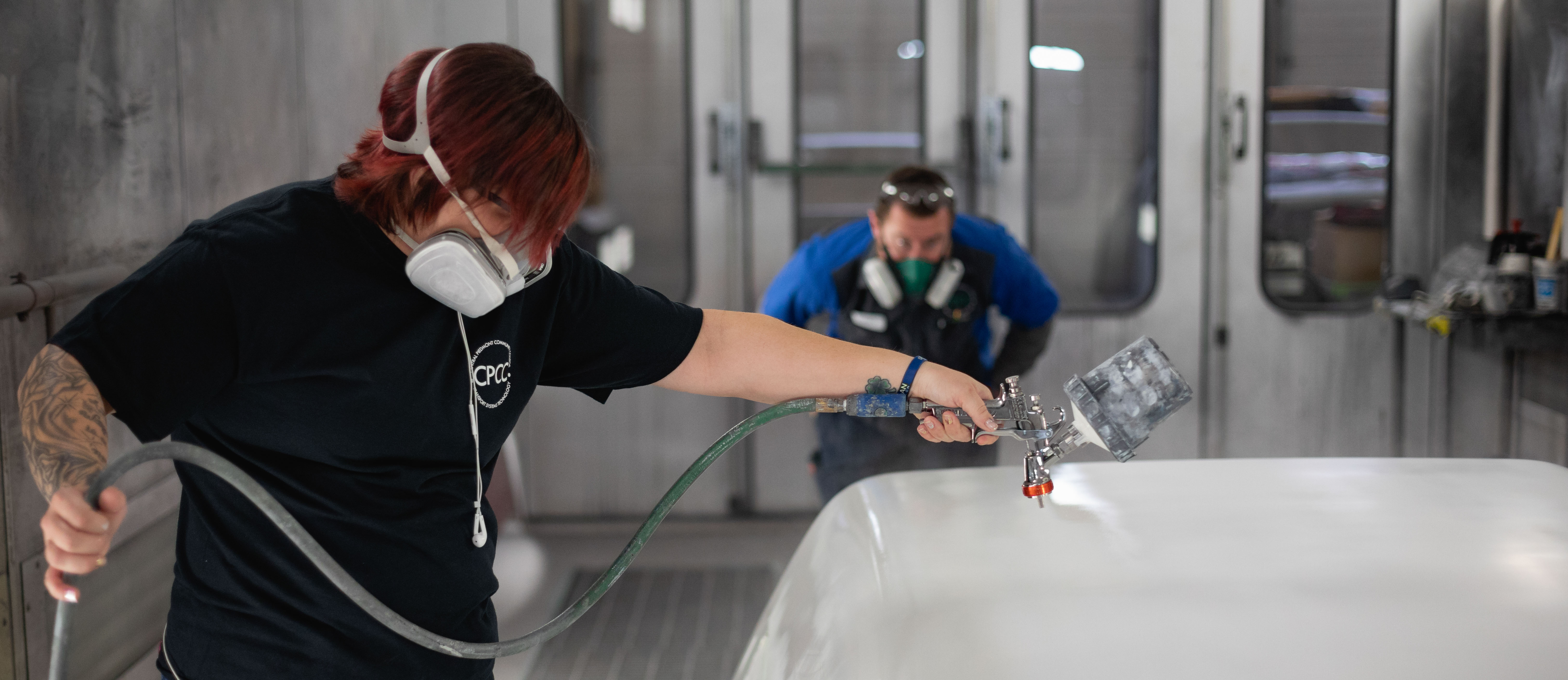 collision repair and refinishing technology lab spraying paint on car