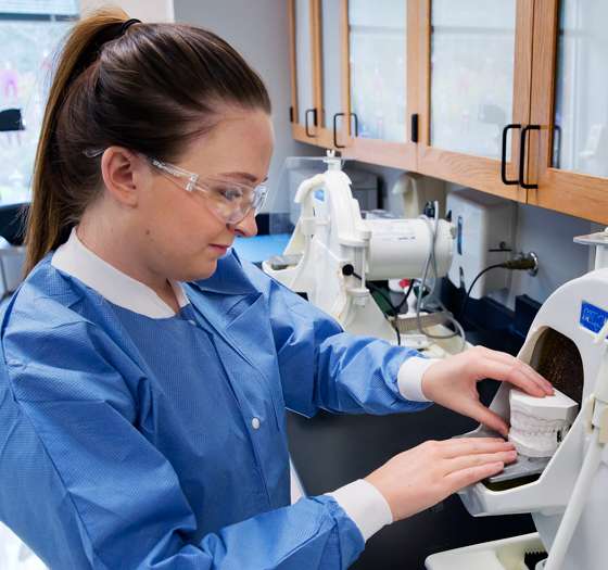 dental assisting student with dental mold