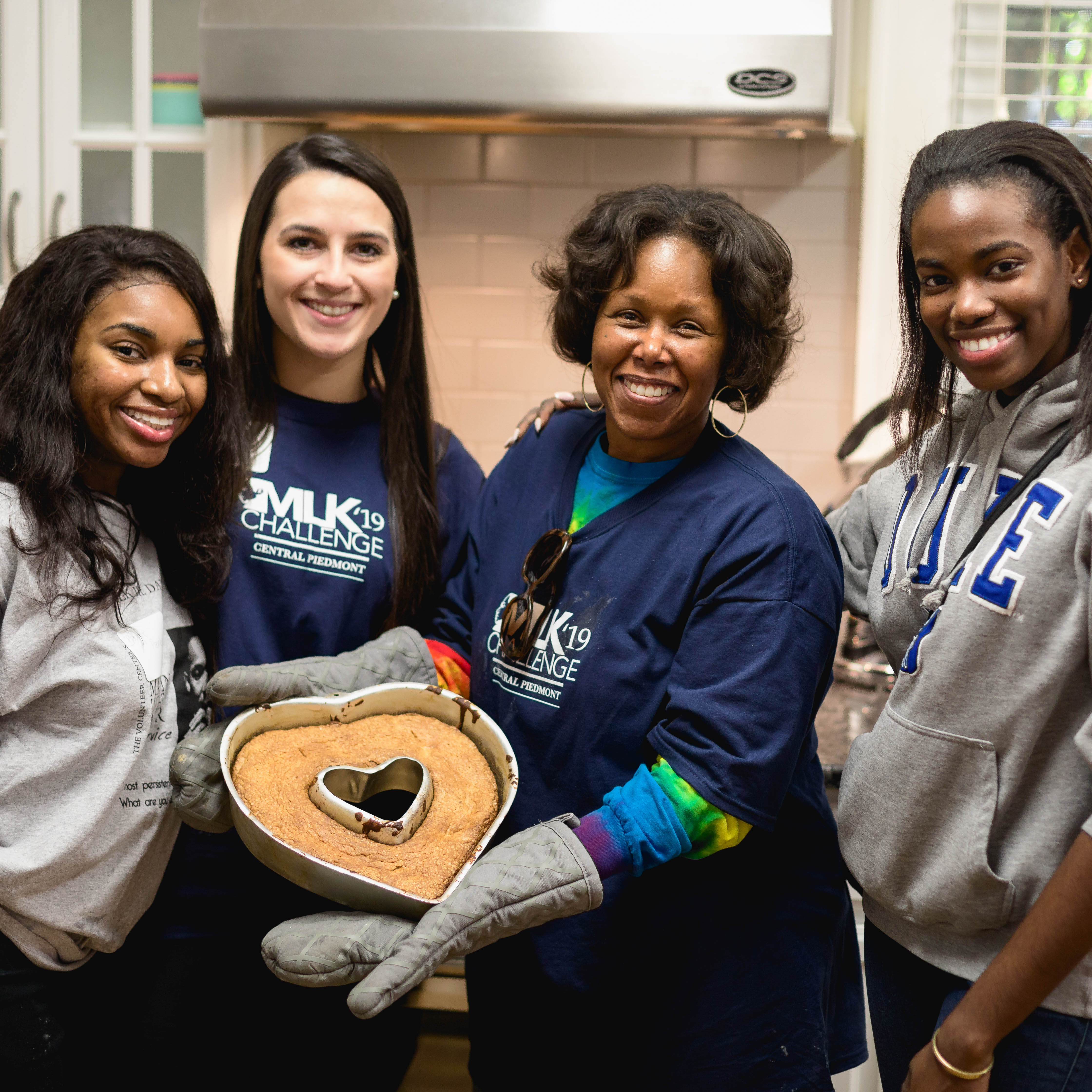 students bake cake with a staff member as part of a service-learning activity