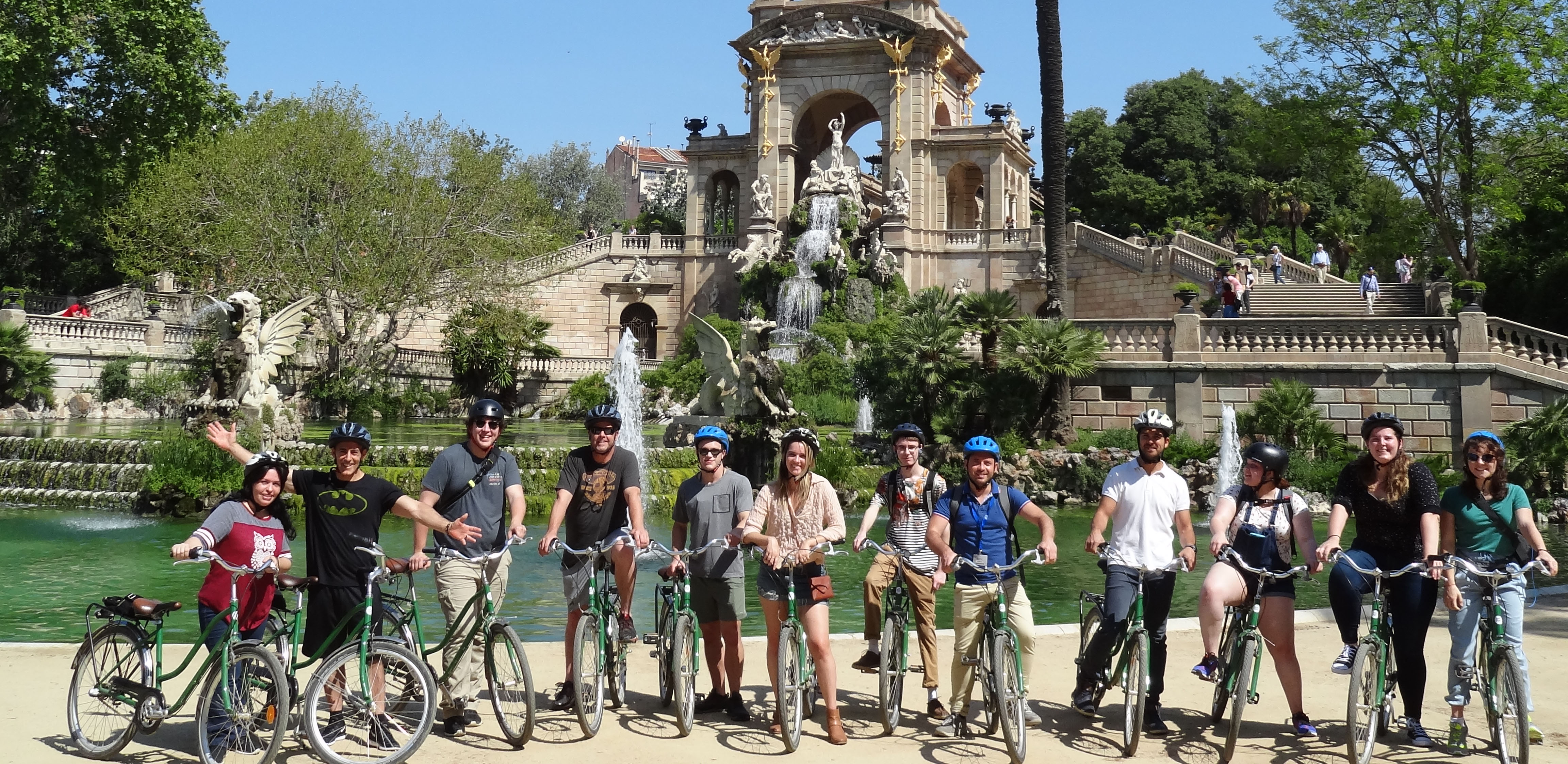 group of students abroad with bikes in front of monument