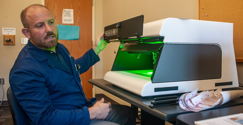 man using device to check document for authenticity