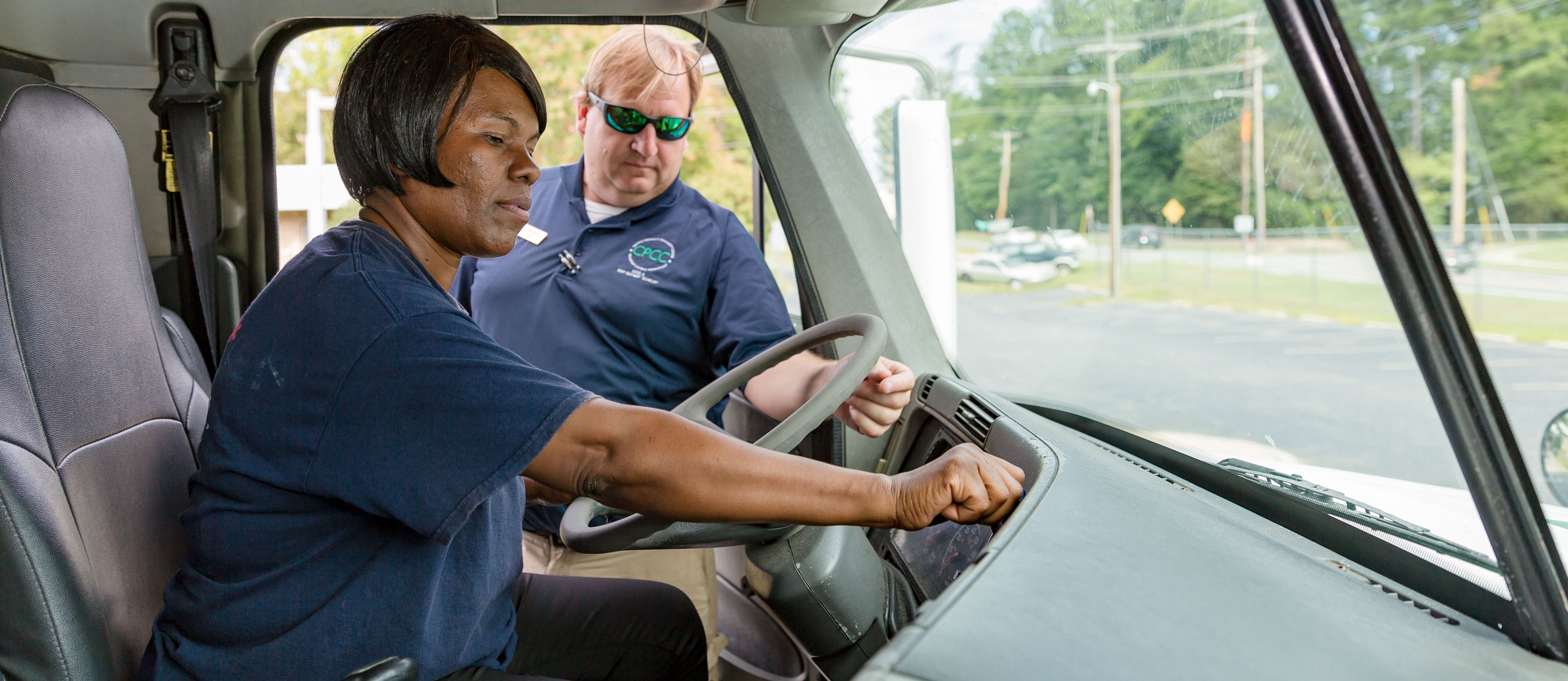 CDL student Vanessa Jackson behind wheel of truck with instructor