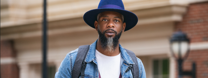 adult student on campus wearing a hat