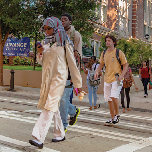 students crossing a crosswalk on campus