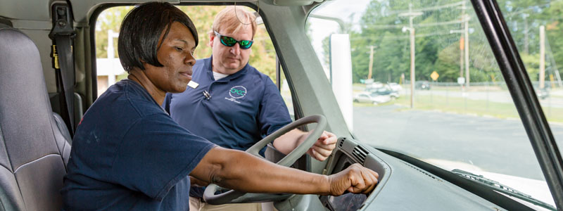 CDL student Vanessa Jackson behind wheel of truck with instructor