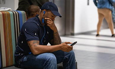 student on phone in lobby area of building