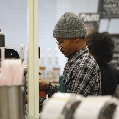 barista behind counter at campus coffee shop