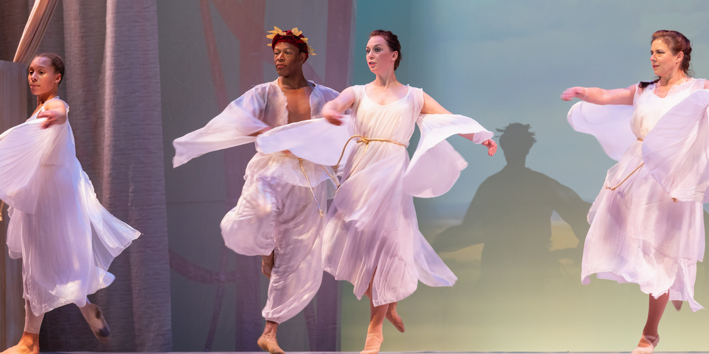 a group of dancers dancing on stage in flowy costumes