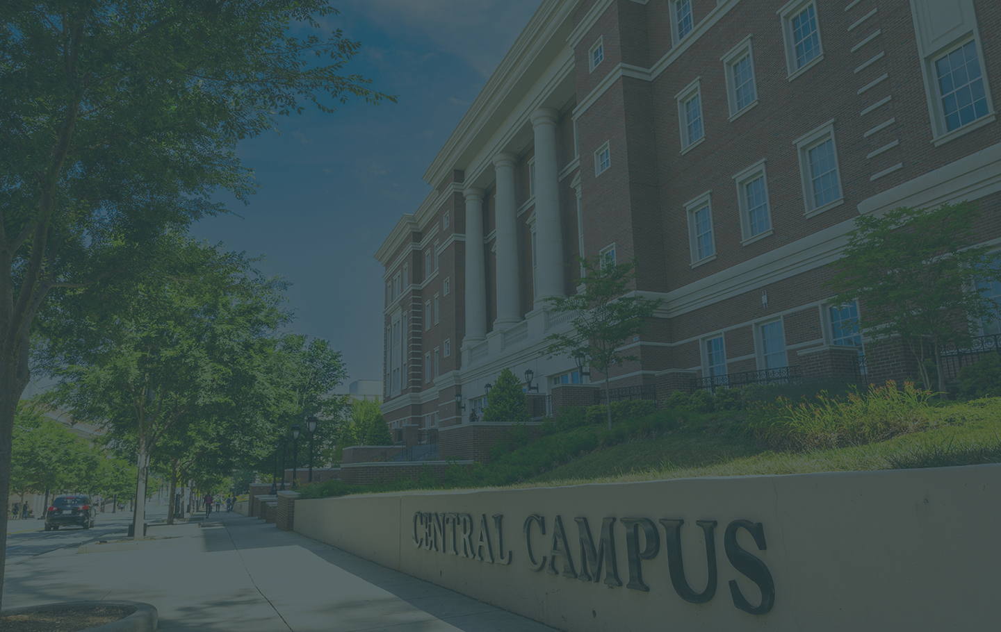 sidewalk in front of Zeiss Building on Central Campus with trees and Central Campus letters on wall