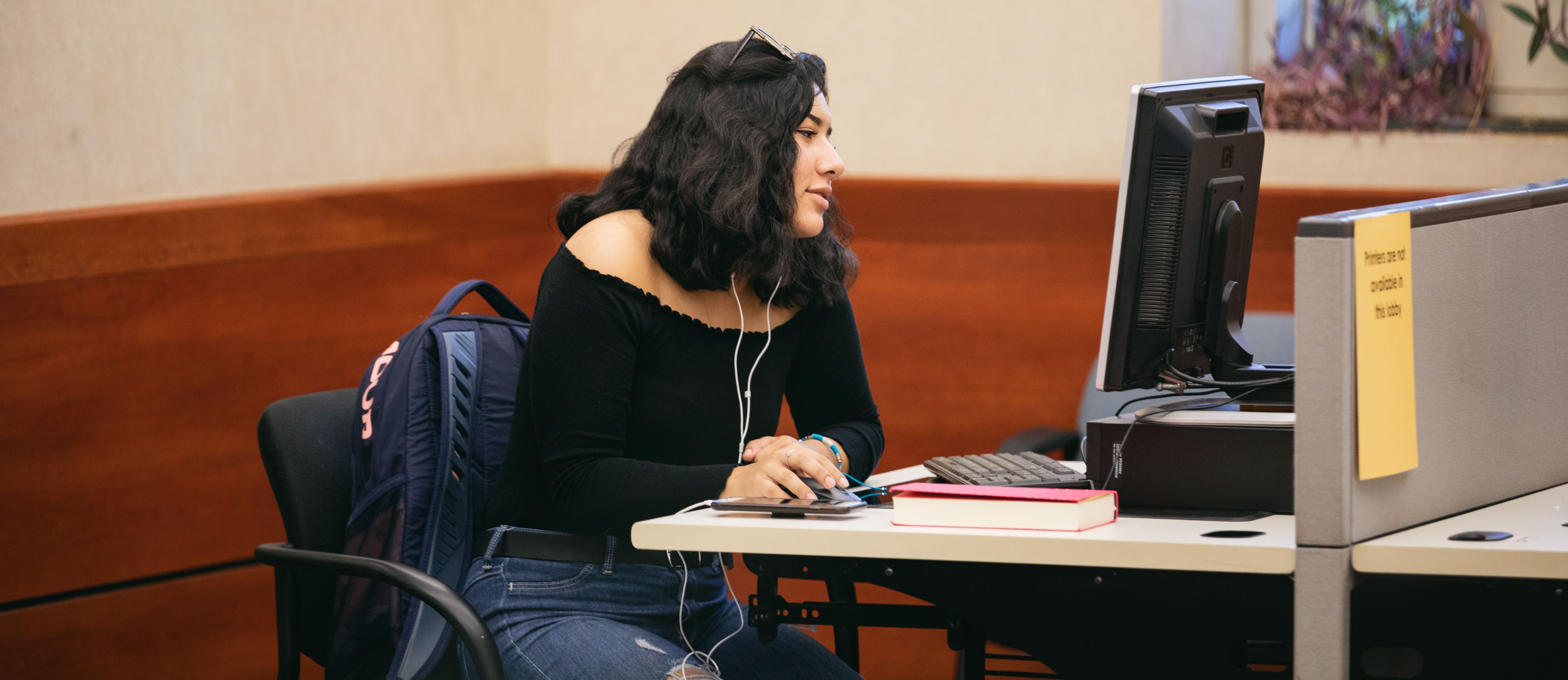 girl working at a desktop computer in a lobby area