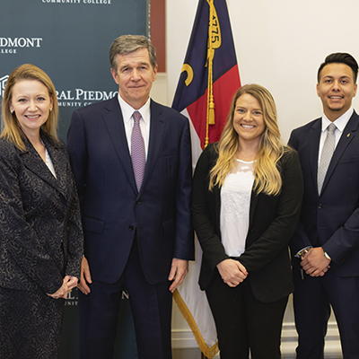 Gov Cooper, Dr. Deitemeyer, and students