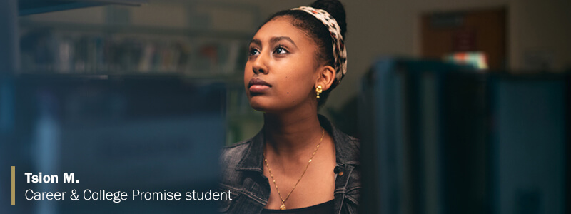 Tsion M., Career & College Promise student, looking up at books in library