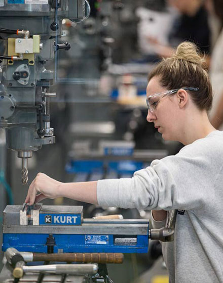 woman using heavy manufacturing machine