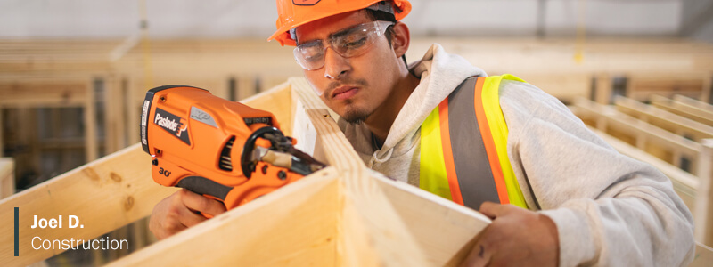 Joel Dr. working with drill on construction site, wearing hard hat