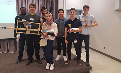 group of Central Piedmont engineering students who placed third at Siemens Engineers' Week holding their project and their trophies