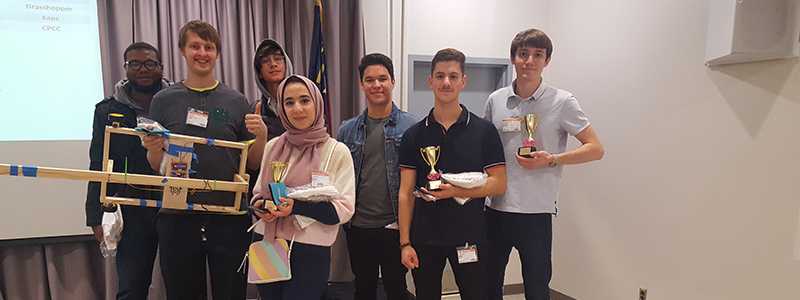 group of Central Piedmont engineering students who placed third at Siemens Engineers' Week holding their project and their trophies