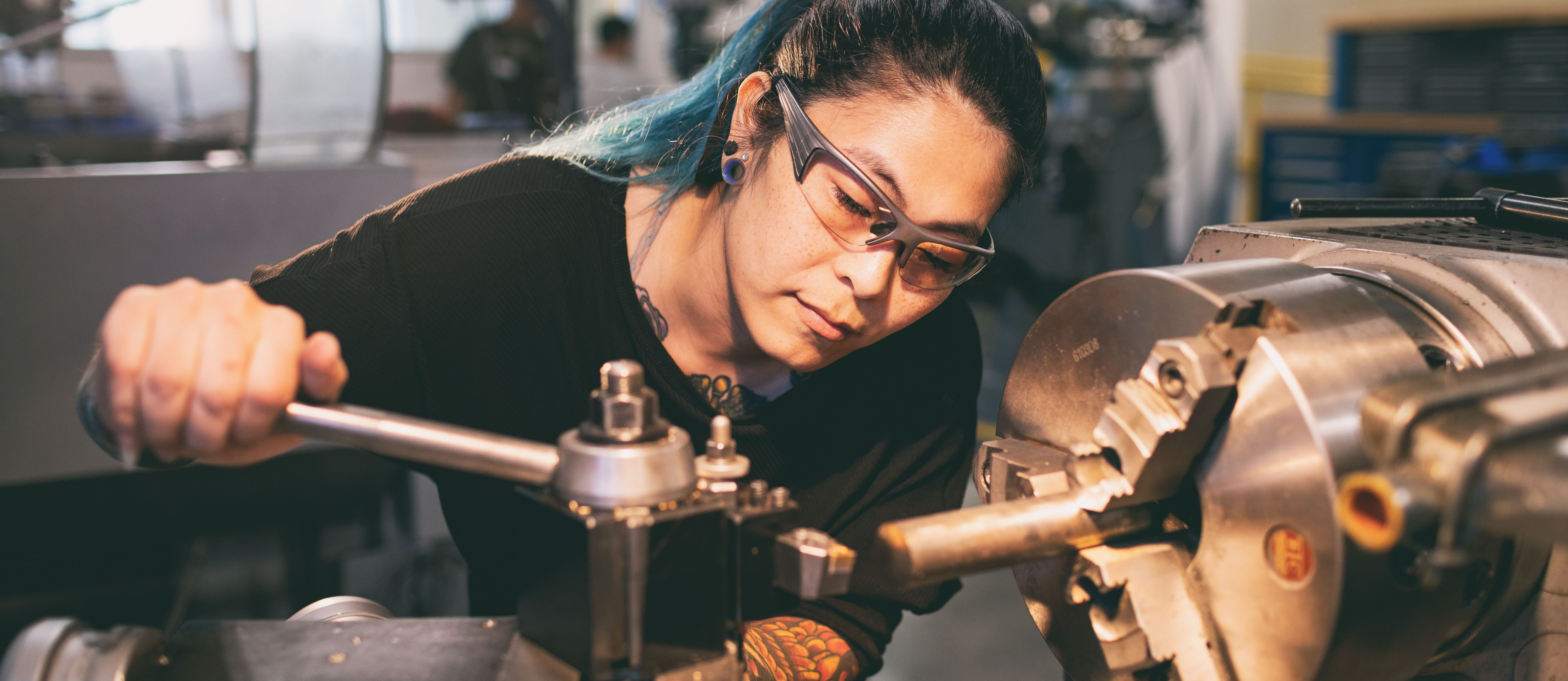 mechatronics student wearing safety glasses tightening a part on a machine