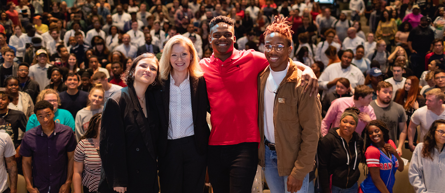 CPCC President Dr. Kandi Deitemeyer with students in front of large crowd at Central Piedmont