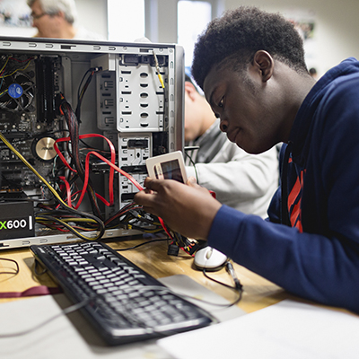 Student working on the internals of a desktop computer