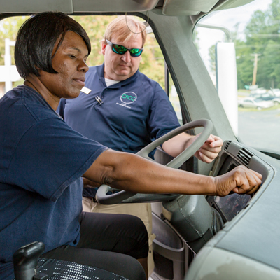 CDL student Vanessa Jackson behind wheel of truck with instructor