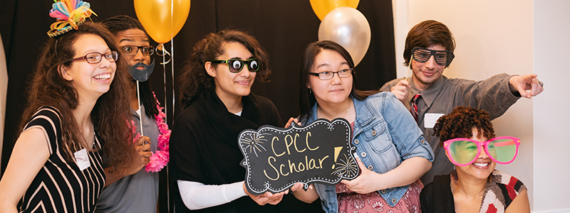 group of students in silly costumes with sign that says Central Piedmont Scholar