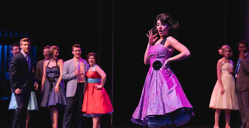 performers in 50s-era costumes on stage