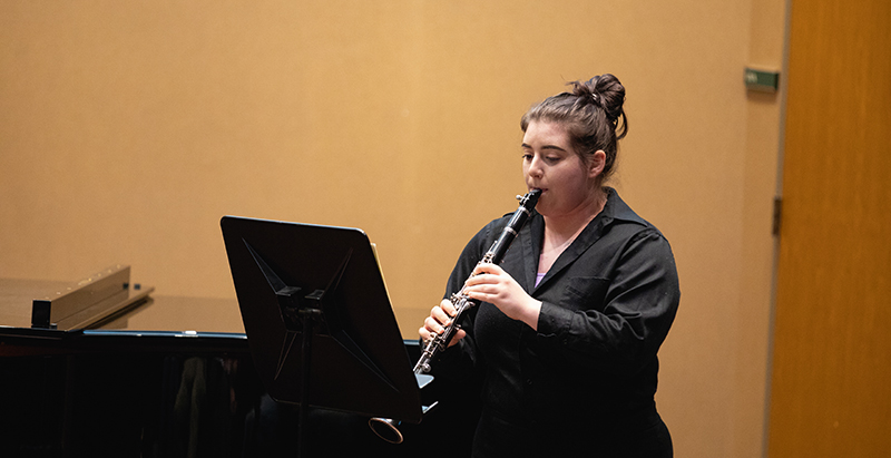 a clarinet player performing at a recital