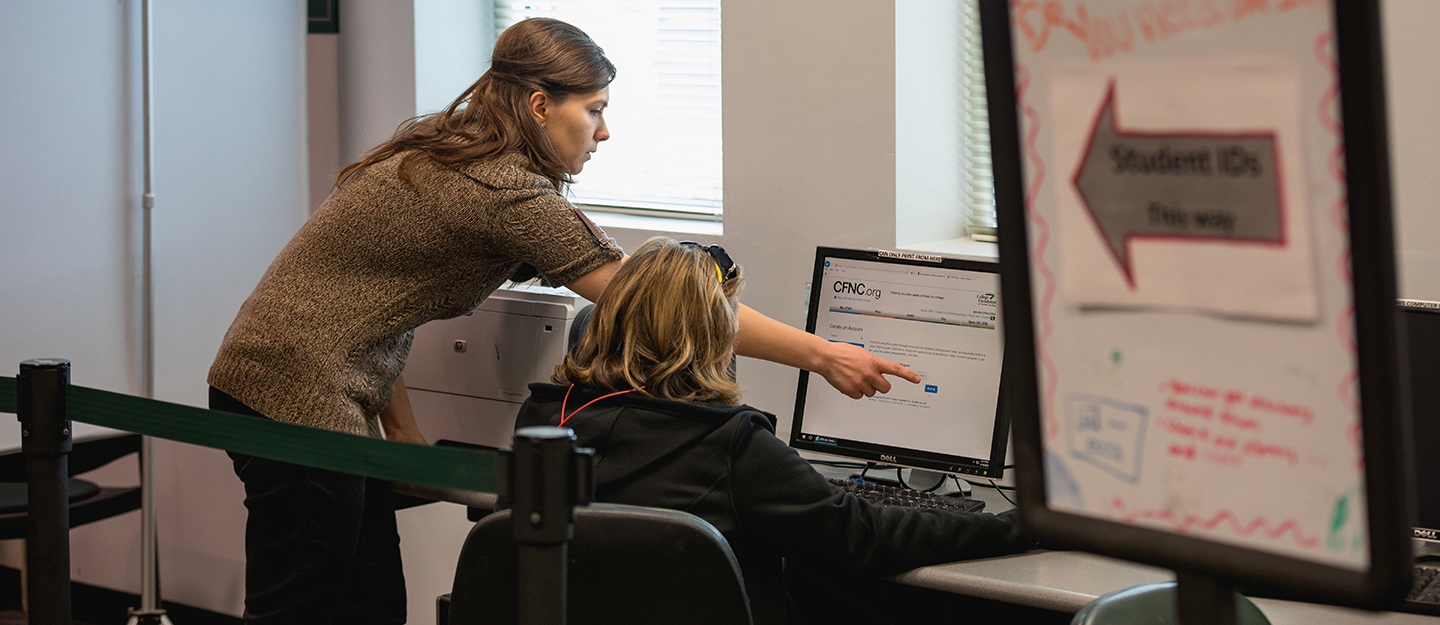 staff helping a student at a computer