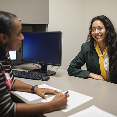 an advisor giving a student career advice at a desk in an office