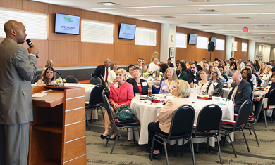 Speaker talking in front of a group at a conference