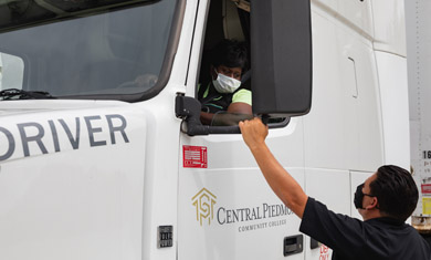 CDL student behind wheel of truck with instructor