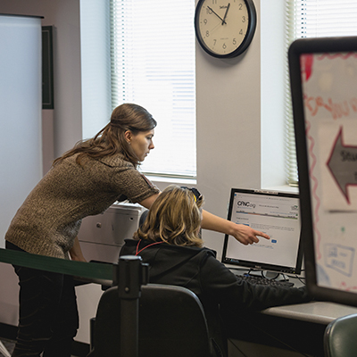 staff helping a student at a computer