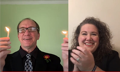 Phi Theta Kappa advisors Beau Bowers and Jenn Conway holding candles and applauding students during fall 2020 virtual induction ceremony