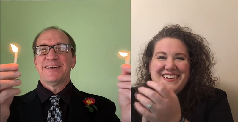 Phi Theta Kappa advisors Beau Bowers and Jenn Conway holding candles and applauding students during fall 2020 virtual induction ceremony