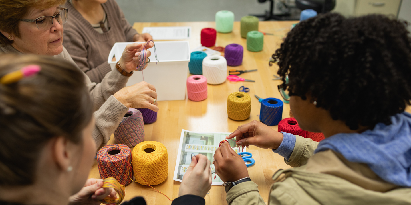 diverse group doing activity with colorful yarn