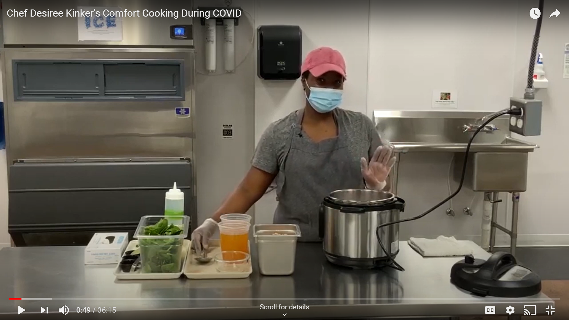 Chef Desiree Kinker demonstrating a recipe in a kitchen, wearing a mask