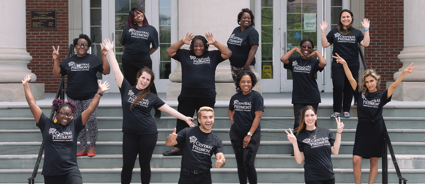 group of diverse STRIVE students doing silly poses on outside steps Overcash Center on Central Campus